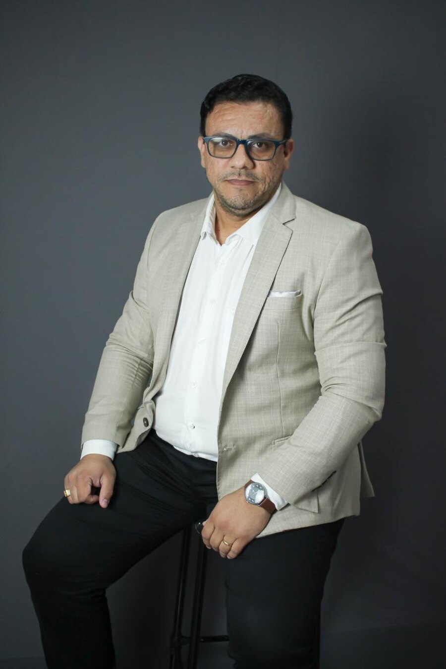 Retrato de Itamar Vieira sentado, de blazer claro