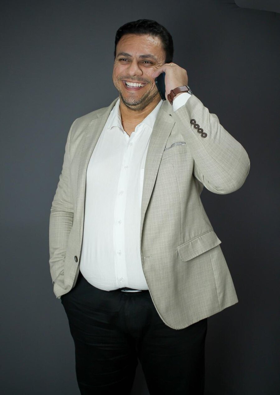 Itamar Vieira sorrindo ao telefone